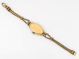 a close up of a gold watch on a white surface