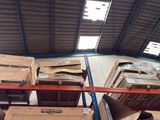 boxes are stacked on a rack in a warehouse with a skylight