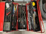 une caisse à outils rouge sur laquelle sont posés des outils