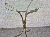 a glass table with a gold metal base and a glass top