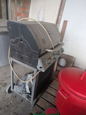 an image of an outdoor kitchen with a grill and a trash can