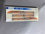 une boîte sur laquelle est représenté un train miniature, posée sur une table