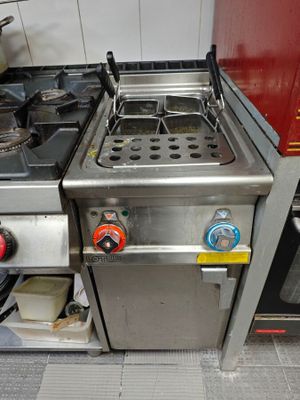 une petite cuisine équipée d'une cuisinière et d'une plaque de cuisson