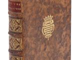 un vieux livre orné d'un emblème doré sur la couverture