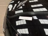 a car parked in a parking lot with a sticker on the hood