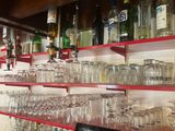 a laptop sitting on a table in front of a wall of wine glasses
