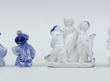 three figurines of people in blue and white sitting next to each other