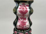 a vase that has a pink and white design on it