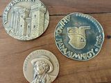 Trois pièces de monnaie sont posées les unes à côté des autres sur une table en bois.