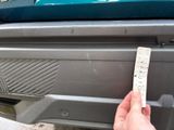 a hand that is holding a piece of paper in front of a car