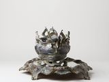 an antique silver plate with a crown on top of it