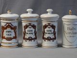 six white and brown canisters with ornate designs on them