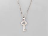 un collier composé d'une clé en argent suspendue à une chaîne, à laquelle est attachée une autre chaîne