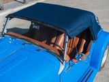 a blue car with a black top parked in a parking lot