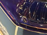 a close up of a blue vase with a gold trim