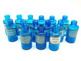 des bouteilles en verre bleues remplies d'un liquide bleu et ornées d'étiquettes argentées sur un fond blanc