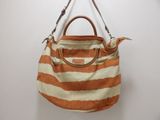 an orange and white striped handbag hanging on a wall