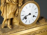 a statue of a man holding a clock on a table