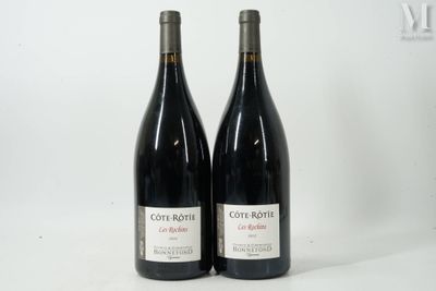 deux bouteilles de vin rouge posées l'une à côté de l'autre sur une table
