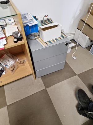 a person standing in front of a desk with a computer on top of it