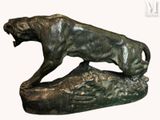 bronze statue of a lion on a rock on a white background