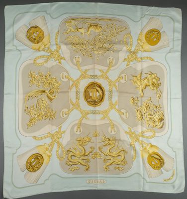 a white and gold square scarf with a design of lions and lions