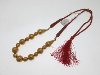 collier en perles dorées avec un pompon rouge et un pompon rouge