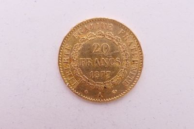 gros plan d'une pièce d'or sur une surface blanche
