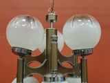 an image of a chandelier with five glass globes hanging from the ceiling