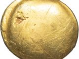 an old gold coin with a hole in the middle of it