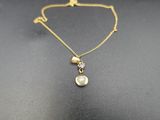 un collier en or avec un pendentif en perle au bout d'une chaîne