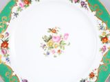 an image of a green and white plate with flowers on it