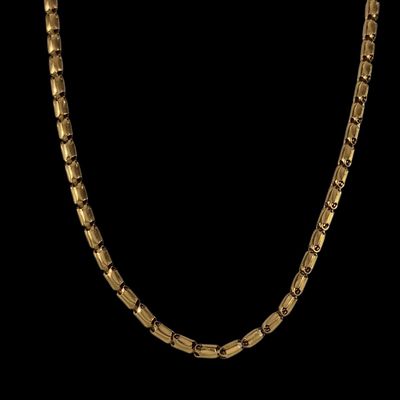 un collier à chaîne en or aux maillons carrés sur fond noir