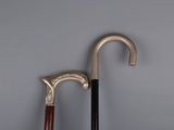 two old walking canes sitting next to each other on a gray surface
