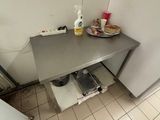 une petite cuisine avec une table et un réfrigérateur