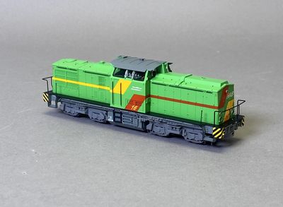 une locomotive verte et jaune sur un fond gris