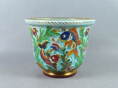 un vase orné d'un motif de poisson, posé sur une table