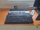 a computer keyboard and a computer monitor on a desk