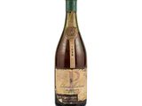 a close up of a bottle of wine on a white surface