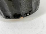a close up of a black vase on a white table