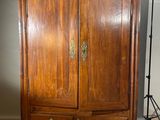 une armoire en bois avec deux tiroirs et une porte
