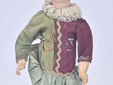 une figurine représentant un petit garçon déguisé en clown