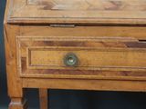 a small wooden desk with a drawer on top of it