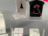 three perfume bottles on display on a clear shelf