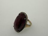 a close up of a ring with a red stone in it