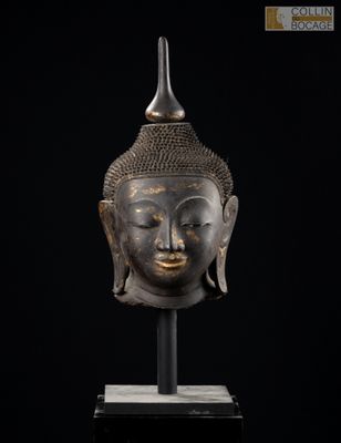 une tête de Bouddha en bronze sur fond noir