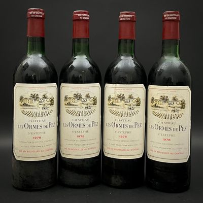 quatre bouteilles de vin sont alignées sur une surface noire
