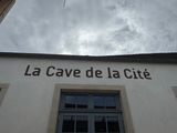 une enseigne sur le mur d'un immeuble indiquant « La Cave de la Cité »