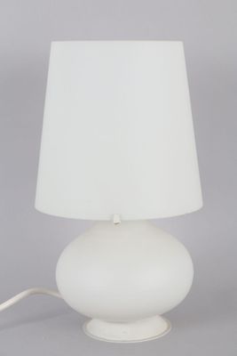une lampe de table blanche surmontée d'un abat-jour blanc