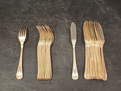 trois fourchettes et un couteau sur une table où se trouvent déjà un couteau et une fourchette